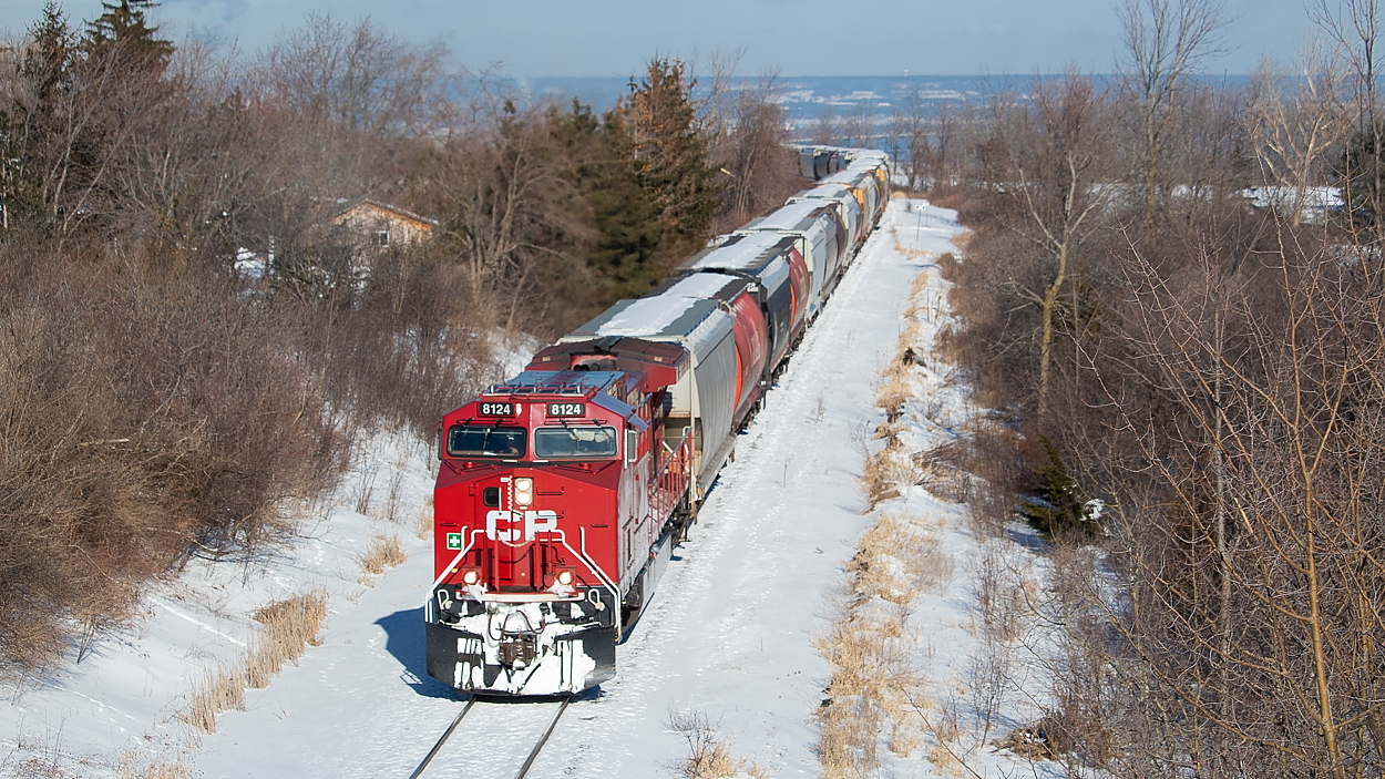 How often do you get to see a unit grain train with 82 loaded hoppers and a rear DPU struggling as they crawl to the top of the Niagara Escarpment? Not all that often! What a treat this train was. With the days getting longer, the forecast looking nice for today, and a lot of trains running late lately, I went to bed last night with a hunch I should go check out CP first thing in the morning before work today. My true target was 143, which has been late several times recently, but when I left the house shortly after 6 I heard a 2-246 heading south to Hamilton from Guelph Junction and figured it would have to do. Little did I know that it was a unit grain train (my personal favourite) headed for Welland for interchange with Trillium! In fact, when I was waiting for them in Vinemount, I heard RTC tell 2-246 that TE11 would be taking 30+ of these hoppers over to Feeder later this same day. It is my understanding from what I observed last month in Niagara Region (explained in this shot of CP at Feeder here and Trillium in Port Colborne here), that these CP-interchanged grain hoppers are for the old Robin Hood mill in Port Colborne (someone please correct me if I am mistaken!).  The area has changed an awful lot over the years, as exemplified in these James Adeney shots of TH&B rock extras here and here. I was inspired by recent discussion in an Arnold Mooney shot of a TH&B train climbing the escarpment to a try an angle such as the one shown in this Stephen Host Shot, but the early morning sun was at such an angle that it was directly on the nose of the train only through this stretch.
