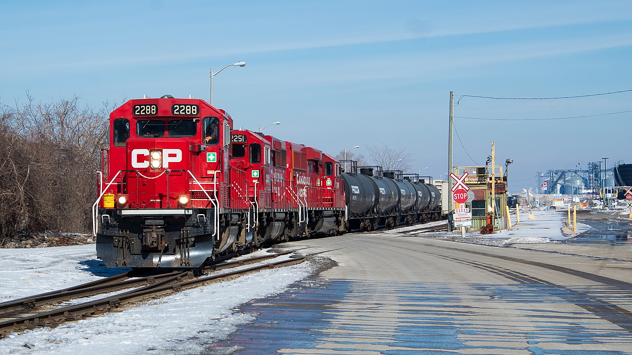 TH41 is pictured here heading back towards Adams Yard after doing some work in the "Far East" of Hamilton's industrial area. The track around this area is joint CN and CP, with customers being served by both. In fact, CN crews were working at the crossing at Burlington Street just south of here when I took this shot. It took me a while to figure out what this trackage is specifically known as, and a sincere thank you to everyone who helped out. I owe the remainder of this paragraph to people other than myself. This area was formerly occupied by Stelco's #2 Rod Mill, and the names for the tracks have stuck. It is my understanding that TH41 is coming off of the Rod Mill Runaround, and the Rod Mill Main Line is the track in the foreground. When the Rod Mill was closed, the land was purchased by the Hamilton Port Authority and the facility torn down. The rail infrastructure was however left in place. The Port turned the area into an industrial park, and Yellowline Asphalt, Crawford Rail Products and Parkland Terminals all utilize rail service here. I believe it was Yellowline Asphalt who CP was serving on this particular day. The grain bins in the background to the right are part of the G3 Terminal on Eastport Drive, which opened in September 2017.