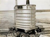 A large transformer on a wide gauge dolly is rotated on a turntable to allow the dolly to be moved to the mounting location of the transformers. The transformer will be rolled off the dolly into position via the rails on top of the dolly and rails at the mounting location. Note that there are four rails on the left side of the turntable and two on the right. The main generator building would be just to the left of the photo. It would appear that the wide gauge rails ran into that building as well. The rails to the right arced around the transformer and breaker areas and connected to the CNR line between Ottawa and Arnprior. My Grandfather worked on several large infrastructure projects in the 1930's and took photos of several locations. Not much in the way of safety gear or appliances in those days other than a hat to keep the sun off your head. 