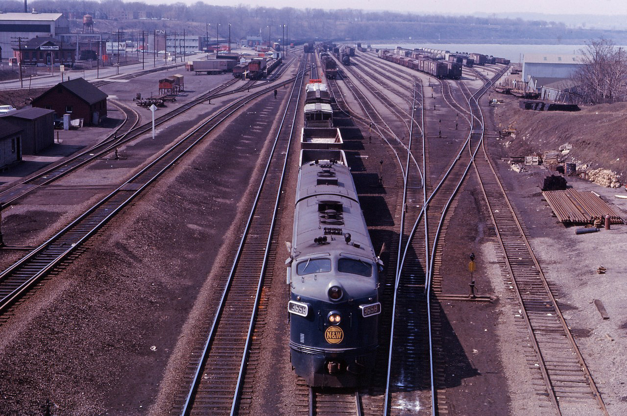 What can you say about this photo from Hamilton's Bay Street bridge over the throat of Hamilton Yard?!? Leased N&W F7As 3658 and 3666 prepare to work the North Yard after crossing over. On the left, you can see the industries which once lay south of Stuart Street; the lead to reach those customers; the track to the James Street Station rising; CN's piggyback ramp; and--in the distance--the Carload Centre/Express building; Diesel Shop; and the then-active South Yard tracks. Tracks in Hamilton Yard were reconfigured during the year 1974; perhaps another member can provide additional information regarding when marine containers started to be handled in Hamilton.