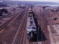 What can you say about this photo from Hamilton's Bay Street bridge over the throat of Hamilton Yard?!? Leased N&W F7As 3658 and 3666 prepare to work the North Yard after crossing over. On the left, you can see the industries which once lay south of Stuart Street; the lead to reach those customers; the track to the James Street Station rising; CN's piggyback ramp; and--in the distance--the Carload Centre/Express building; Diesel Shop; and the then-active South Yard tracks. Tracks in Hamilton Yard were reconfigured during the year 1974; perhaps another member can provide additional information regarding when marine containers started to be handled in Hamilton. 