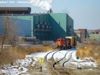 A train rounds the curve on the Kenilworth lead at the far end of the N&NW spur, with a single boxcar it looks  rather diminutive to the Dofasco factories behind them. The CN mainline here was likely re-aligned for the <a href=http://www.railpictures.ca/?attachment_id=35394 target=_blank>Ore Trains</a> along with the Ore Train lead constructed just around the curve of this photo. To the left is the Dofasco yard (track owned and operated by Dofasco). This is what remains of Dofasco track in this part of Hamilton the mainline once stretching from about here all the way down beyond Depew St! Their line is mostly ripped up now and what remains looks rather forlorn except for the track inside Bayfront which is still used 24/7 by bottle trains and coke oven moguls.<br><br>My first time actually shooting CN properly down here in the "hole" - I do miss the SOR though. Saturday Morning's yard job was switching the yard while I ran into rp.ca Moderator Ryan Gaynor. We chatted a bit while shooting the geeps switching the yard, then the geeps ran under us with a single boxcar well past any yard leads -- I knew right away they were going down the hole. Box car? Surely for Parkdale Warehousing all the way down the other end of the N&NW spur? Yup, so we got to follow all the way down in quite nice light. Not all jobs are daily, in fact, it seems weekends can be pretty quiet. We ran into James Knott down there also making for a trio of regular Hamilton guys following the action. Great to see y'all. <br><br>With thanks to Tim Stevens, the Hamilton yard jobs are as follows: YHM013 - 0700. YHM303 - 1500. YHM313 - 1400. YHM603 - 2300. Not all jobs are daily but two sets of power are assigned to the yard at the present time. Weekends seem to be quiet in Hamilton but there is some action.