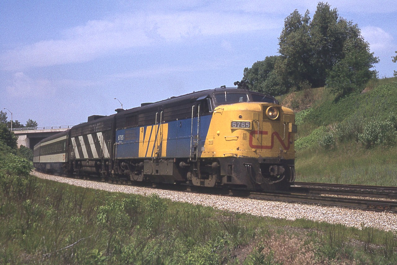 Misplaced my notes. However, the slide is marked 'July 1978' and this is just your standard eastbound passenger train of the day coming off the Dundas Sub to Bayview & the Oakville Sub. The lead unit on this train, 6765 was retired by 1080 but has been preserved.
A number of units in the early years of VIA when painted to the corporate colours retained "CN" on the nose for a couple of years. Why?