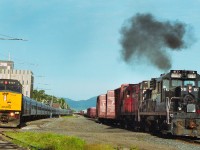 The eastbound VIA Ocean makes a station stop at Campbellton, NB while the New Brunswick East Coast Railway assembles a train in the yard. The NBEC power is an ex-CP Rail RS-18, paired with another RS-18 that has yet to be repainted.  The NBEC was a shoreline that operated from 1997 until CN re-purchased it in 2008.