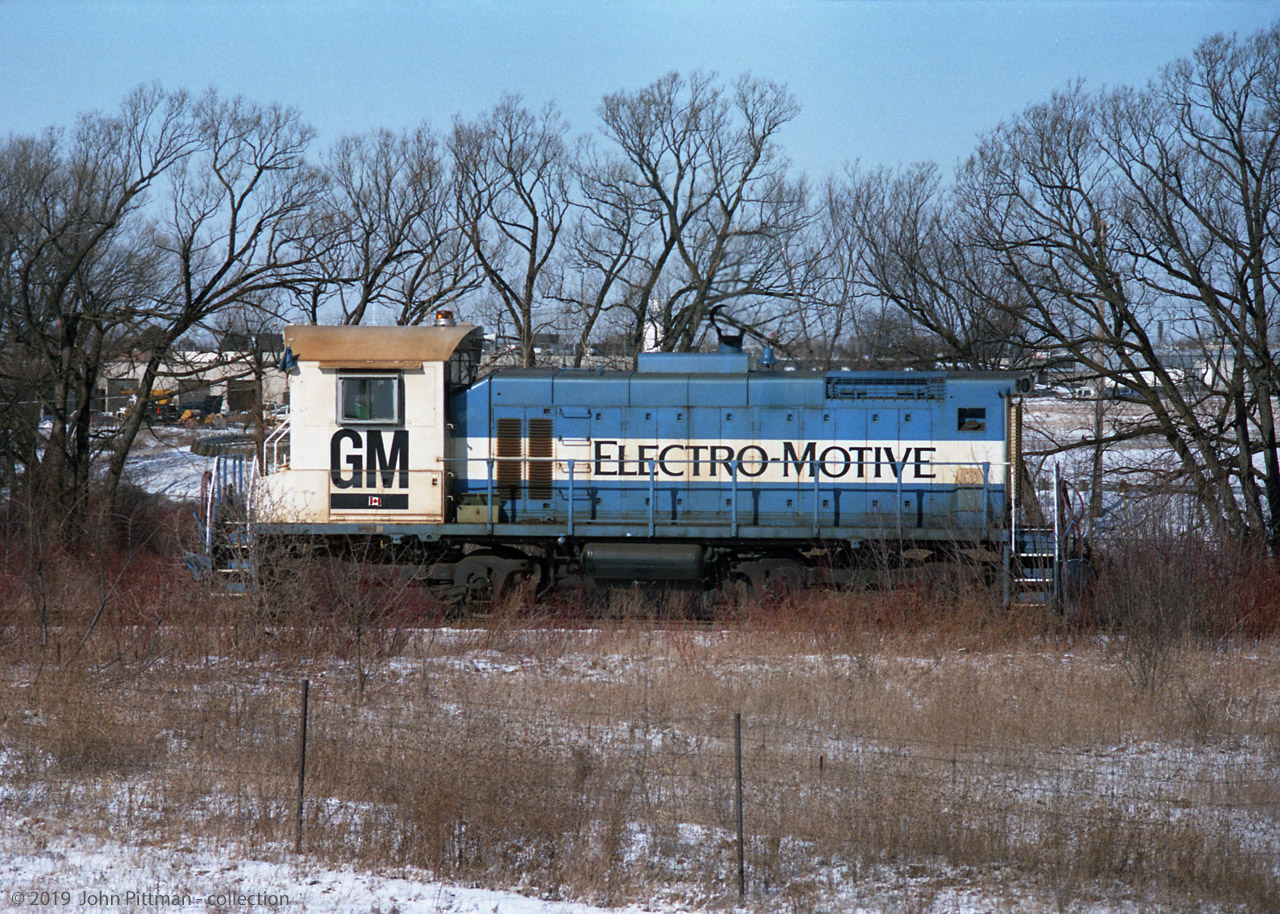 GM Diesel Division plant switcher "1" was an EMD SW1001 acquired from EMD LaGrange in 1994. At the time  of this picture, the EMD paint scheme is only slightly modified with a small Canadian flag sticker on the cab side. Sources indicate it was EMD-built in Dec 1979, and retained its EMD unit number 117 until 1996.  
The location could be the west side of the wye to the GM test track (and CP connection) that runs alongside CP's Galt Sub. 
Around 2000 this locomotive received a 50th anniversary paint scheme with a map of the world and arcs from London to overseas customer nations. At some point after my picture a big black can-like object got installed on the hood-top; I suspect it's an exhaust filter that makes operating the loco inside the plant more acceptable.