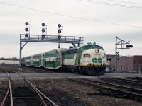 About a mile east of London station, GOT 908 APCU leads 3 GO Transit bilevel coaches eastbound on the Dundas Sub, a long way from their usual territory. F40PH VIA 6447 is on the back providing all of the motive power.<br><br>Looks to me like a scheduled VIA train operating with borrowed GO Transit equipment, perhaps because of a shortage of operational VIA coaches - maybe the LRC coach fleet was "grounded"? Since GO Transit's coaches use a higher HEP voltage than VIA for HVAC & lighting, a GO Transit APCU, APU, or locomotive has to provide the Head End Power. <br><br>My other GO train in London pictures from March and April 1992 mostly consist of an F59ph and three bilevel coaches. APCU's were little used once GO had enough F59ph's. GP40 GOT 720 was trailing unit of a CP freight train through London on 1992/4/17.