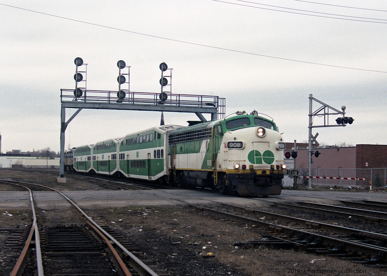 About a mile east of London station, GOT 908 APCU leads 3 GO Transit bilevel coaches eastbound on the Dundas Sub, a long way from their usual territory. F40PH VIA 6447 is on the back providing all of the motive power.
Looks to me like a scheduled VIA train operating with borrowed GO Transit equipment, perhaps because of a shortage of operational VIA coaches - maybe the LRC coach fleet was "grounded"? Since GO Transit's coaches use a higher HEP voltage than VIA for HVAC & lighting, a GO Transit APCU, APU, or locomotive has to provide the Head End Power. 
My other GO train in London pictures from March and April 1992 mostly consist of an F59ph and three bilevel coaches. APCU's were little used once GO had enough F59ph's. GP40 GOT 720 was trailing unit of a CP freight train through London on 1992/4/17.