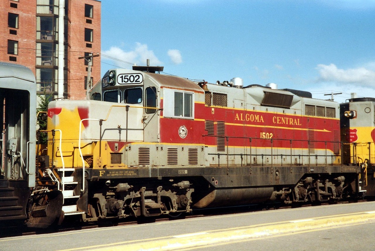 On a quick glance this looks like a chopped-nose Algoma Central GP7, however it's actually Wisconsin Central GP7L-m 1502, ex. AC 169.  The WC took over the AC on February 1, 1995, and apparently they wasted no time getting to work on the remaining GP7L-m on the Algoma Central roster.  WC must have been power short, or maybe the paint booth was backed up since this unit was returned to service before getting repainted WC.  It is shown here as the 2nd unit on the Agawa Canyon Tour Train at the end of the run in Sault Ste. Marie.  The unit was retired in 2005.