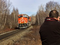 With another foamer perched nearby, a late Q120 rounds the bend at Berry Mills, approaching their next crew change point of Moncton, New Brunswick. This train hit a mudslide west of Edmundston, New Brunswick, (hence the condition of the units). Fortunately for everyone involved, the train stayed on the rails. 

April 14, 2019. 