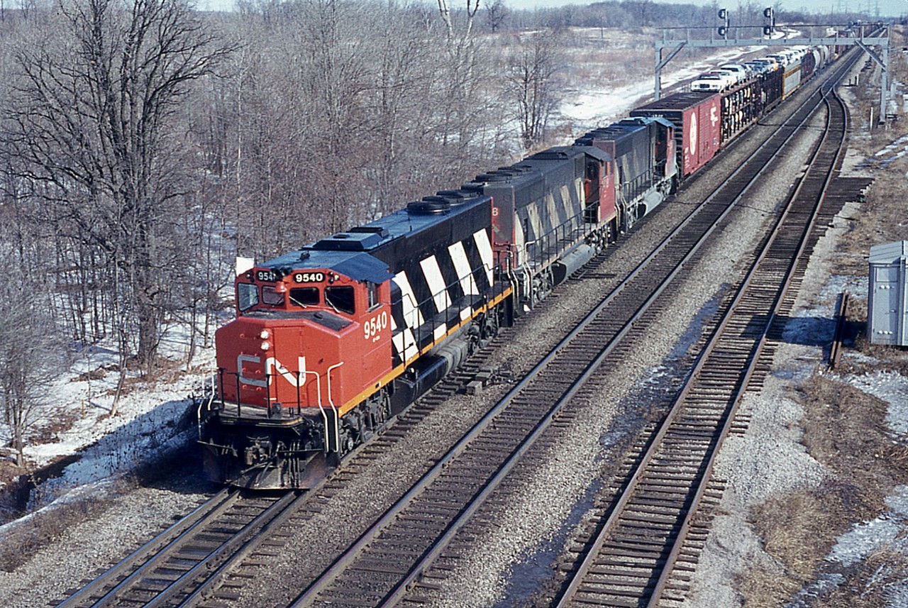 GP40-2L (W) trio CN 9540, 9418 and 9474 are seen from Waterdown Road bridge westbound on a very pleasant morning. This location is of interest because off on the North (left) side is the site of the present day Aldershot GO station and parking lot. It was all so different back in 1977, and one would be hard pressed to find any connection with today's busy scene.