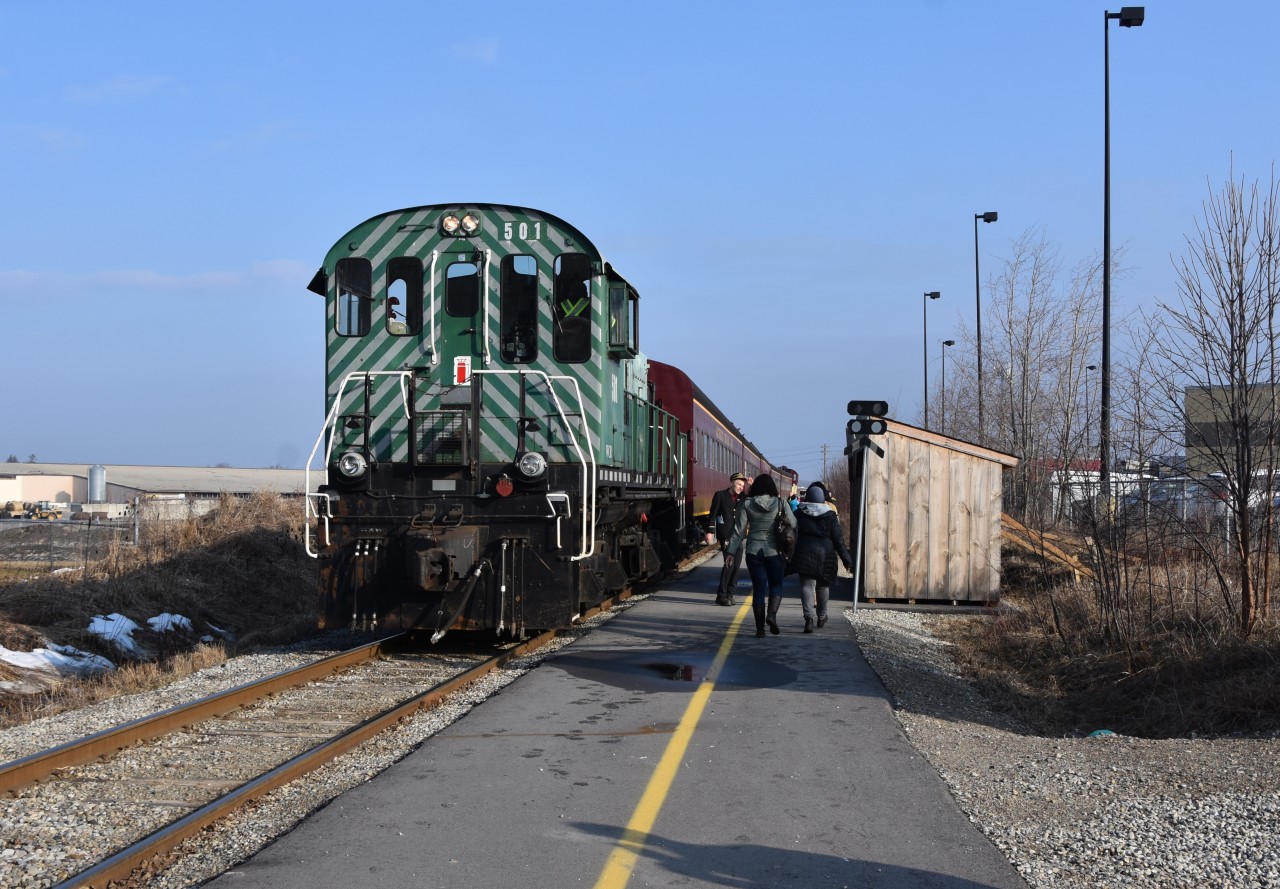 That’s my ride to the 2019 Elmira Maple Syrup Festival!!   Just before 9am on the first Saturday of April (which is usually the day Elmira hosts its annual Maple Syrup Festival), the Waterloo Central Tourist Train is seen paused just north of the Farmers Market Road crossing in North Waterloo and passengers walking down Waterloo Central’s actually new freshly paved platform at the Market who will soon board the train and from there, the train will take them and mysel to the festival!