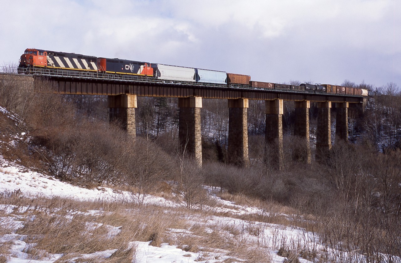 A pair of 2400's lead 385 over the single track Credit River bridge on the east end of Georgetown Ontario. This structure has changed significantly in the years since.