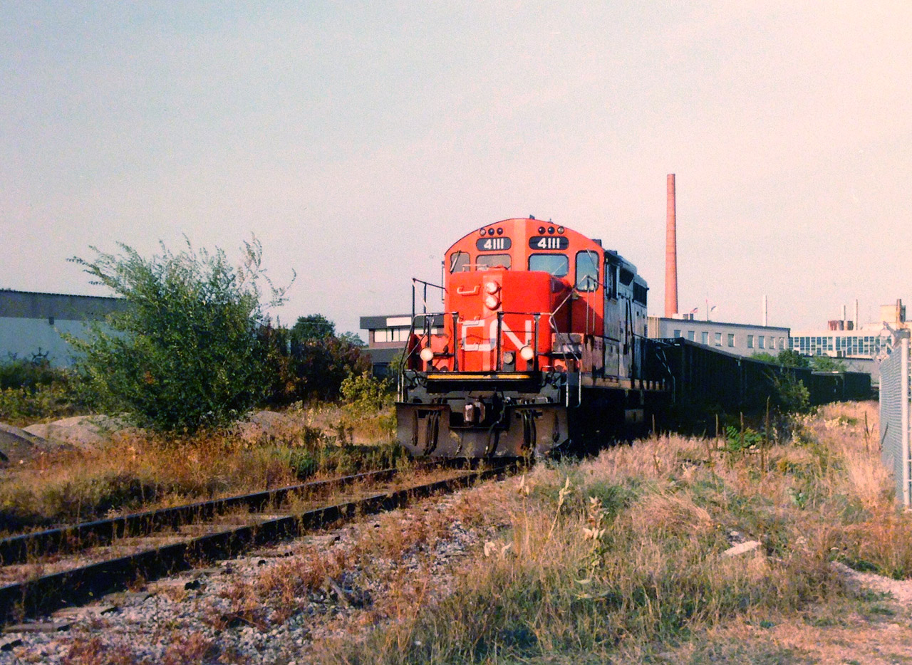 CN GP9RM 4111 leads the 15:30 Kitchener local down the Huron Park Spur in Kitchener less than a month before the original of takeover of the Goderich-Exeter Railway in November 1998. In the last two decades this area has changed dramatically with the installation of the GO Transit layover facility and the CTC installation on the Guelph Subdivision. Thank you to Stephen Host for all the photo editing work on this one.
