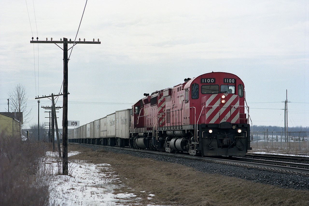CP's #528 Roadrailer has just left London, running eastbound by mile 109 on the GALT sub headed toward Toronto. Control cab 1100 and permanent mate CP SD40-2 #6043 are the power. The 1100, formerly CP C-424 #4236, had its traction motors removed and was de-engined in 1995 to become strictly a cab only. The unit was retired in 2004 and in 2008 it was donated to Exporail in Quebec.