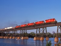 Elephant style in the low evening sun, CP 5549 and helpers 4565,4739,4741,4720, lead a westbound across the Trent River at mile 102 on the CP's Belleville Sub.