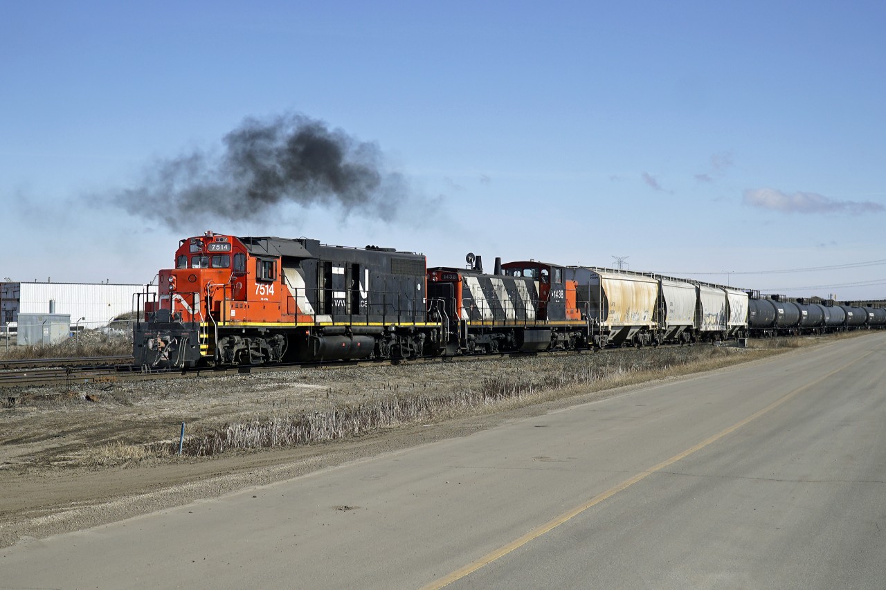 GP38-2 CN 7514 and GMD! CN 1438 push back into Clover Bar yard with a long cut of tank cars.