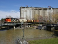 Water is very high in and around Montreal, with the army having been called in to help with flooding. The high water is evident as CN 9547 backs up towards the Bickerdike Pier, as it crosses the Lachine Canal with some grain cars.