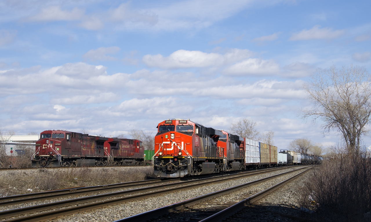 CN 377 with a pair of ES44AC's (CN 2946 & CN 2870) is heading west through Dorval as it passes CP 143 with a pair of AC4400CW's (CP 9759 & CP 8569) on the parallel CP Vaudreuil Sub. CP 143 will take off in a few minutes once the conductor is onboard.