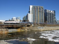After being involved in a grade crossing accident in January 2018 heritage unit AMTK 145 was repainted, here it pushes the <i>Adirondack</i> towards Central Station in Montreal before departure, with the unit reflected in the Peel Basin.