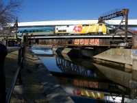 VIA 900 leads VIA 22 over the Lachine Canal and will be in Central Station in five minutes. Behind the train is a recently erected bridge that will bring the rails of the REM light rail project over the canal.