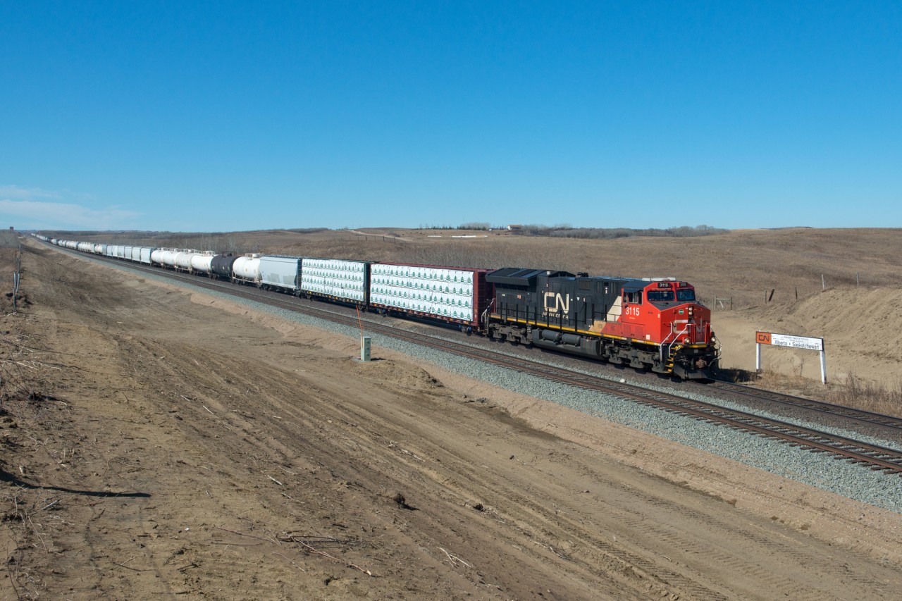 While I am standing in Saskatchewan, CN 316 is in Alberta... for another couple meters at least. The elevator at Butze can vividly be seen in the distance. An old CN marks the provincial border.