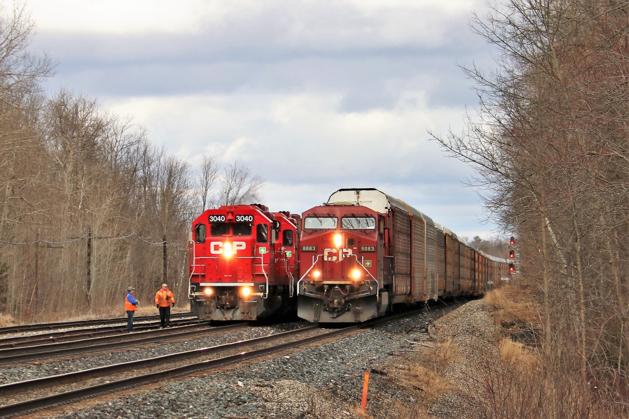 The crew of T69 (CP 3040) depart their train to inspect CP 147 led by a solo CP 8883 hauling 4732 feet of auto racks as it passes them on the south track at the exit of Guelph Junction.