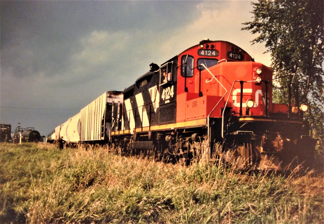 Engineer Dennis Fleet looks back at his train as the crew of the 15:30 Kitchener Job attempts to work ahead and depart Elmira, Ontario on September 11, 1996. The crew is finishing switching at Sulco Chemicals before an approaching super cell descends on the area. CN GP9RM 4124 would soon throttle-up and haul its sizeable train back to Kitchener along the Waterloo Spur eventually being overtaken by the fast moving storm.