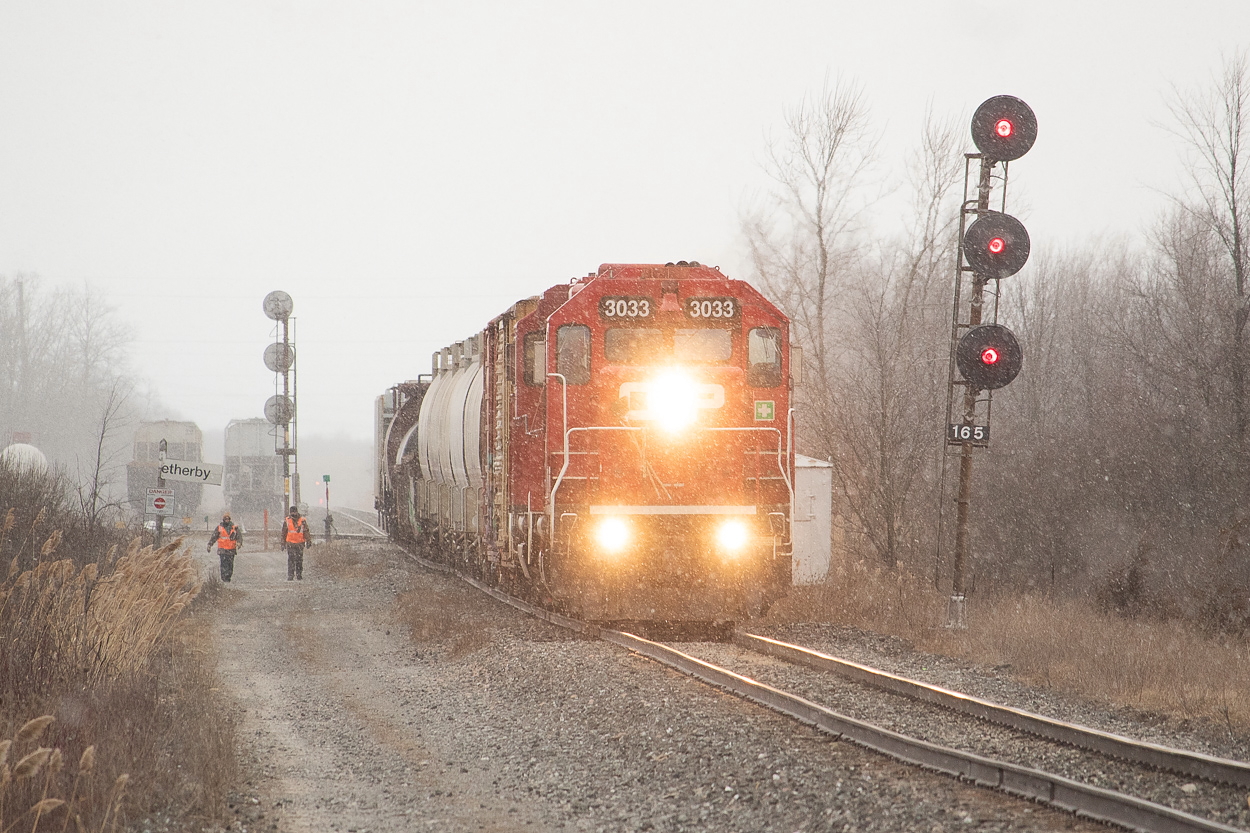 I had just finished shooting Trillium in Port Colborne (a couple of shots here and here) and was heading back to the Port Rob area when I heard CP TE11 talking to CN RTC. I had no real clue where they were, and was in fact heading somewhere else to look when I happened upon them at CN's Southern Yard (which in hindsight would have been the obvious place to look first) working the interchange. It was a very windy day with snow squalls at times, and here a couple of crew members are caught up in some unpleasant weather as they walk the length of the train to the head end so they can return to Welland Yard. I felt bad for them until I realized I was out standing at the side of the road in the same conditions they were in.