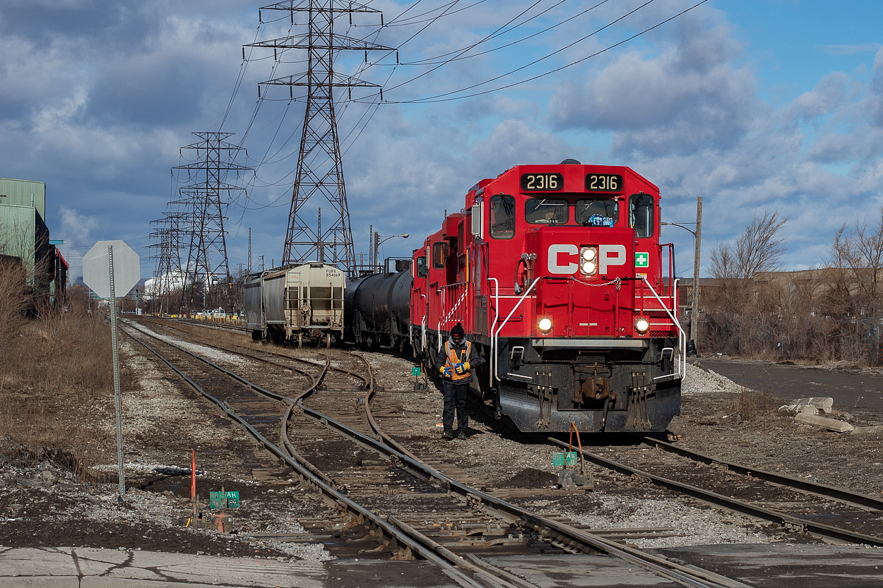 TH41 is pictured here near Ottawa Street in Hamilton, on the Beach Branch at the interchange. The two hoppers in the foreground are empties for Bunge, and the crew is about to cross Ottawa Street to clear a switch and shove back on the track to tie on a third hopper. They referred to the three as "the three Bunge hoppers", though they'd set off a Nova Chemicals hopper which I thought was odd. My instinct was correct, and I saw CN return the hopper to CP at Adams Yard the very next day, noted in the caption of this shot  here. To see CN working this interchange, I 7posted a shot of them lifting cars here.
