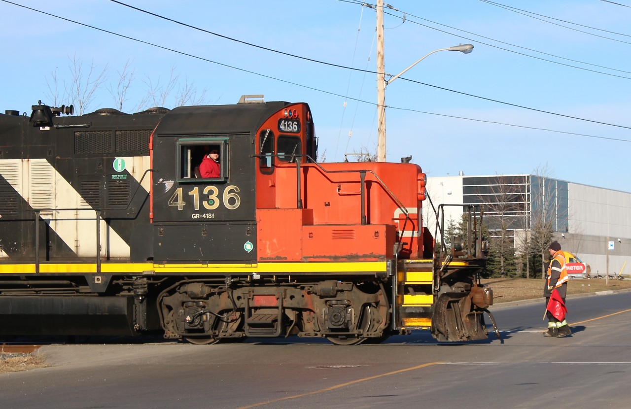 The late day light accentuates the classic GP9 details, as CN local 547 switches out cars on the Glass Lead in Milton. The name of the spur comes from the large glass plant that was served here up until its closure and demolition several years ago. Today the former glass plant site is being redeveloped and there are still a few industries served along the short spur. The brakeman is seen in the process of returning to the cab after flagging a busy crossing, and the train will now head back to the Halton subdivision to complete switching local industries before returning back to Aldershot.