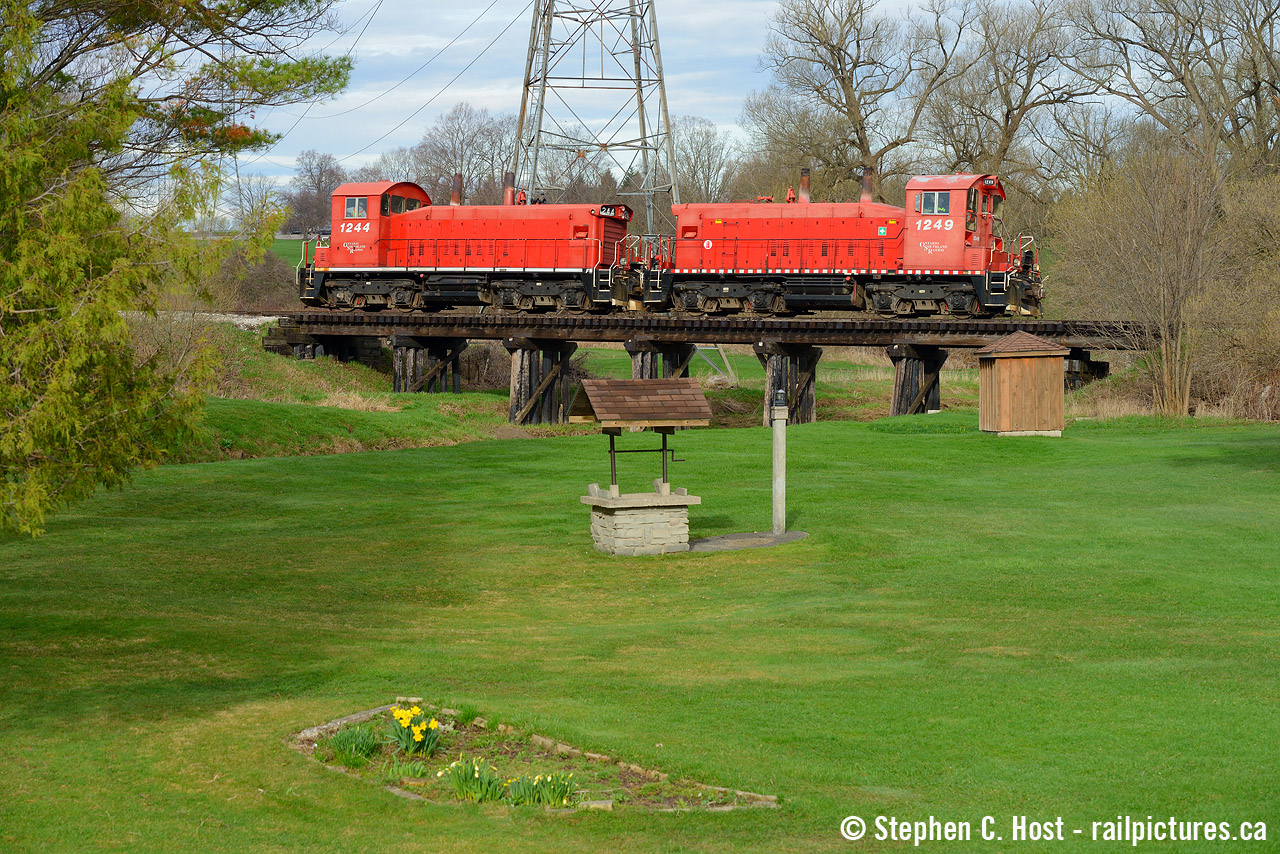 Spring is in the air as a couple of lilys bloom in this nicely manicured backyard complete with a quaint all wood railway trestle. The pair of pups on this day's Cayuga job fit perfectly on the bridge as they head light power to St. Thomas and onward to work St.Thomas, Aylmer, Tillsonburg, and Courtland. The day was mostly cloudy with a few sunny breaks, and the sun came out for me right when it counted and I was thankful for this one to turn out.  You can shoot this pretty scene from putnam road without issue.