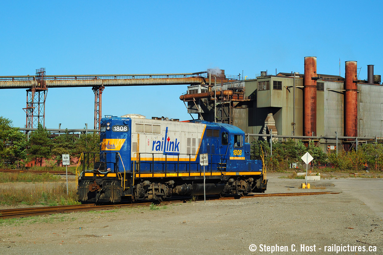 The Southern Ontario Railway is seen working In the shadow of a giant, in this case, Stelco. The building in background is all that remains of the "D" Blast furnace complex, most of which was demolished in the early to mid 2000's (which would have stood at left). I'm not sure what this structure is used for, but it's still there today. This was back when you could drive back into some of the port lands, as long as you didn't get caught by port patrol. It was all fenced off around 2011. Corrections welcome.