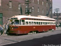 A warm June day in 1961 finds TTC A8 PCC 4527 taking on a load of passengers at the southeast corner of Bathurst and King Streets, working the "Fort" route north to St. Clair. The Fort car was a branch that operated along Bathurst between Fleet Loop (on Fleet St. west of Bathurst), up Bathurst to Woseley Loop at Queen St., or up to St. Clair Avenue as this car is signed.<br><br>The A8-class of all-electric PCC streetcars were a group of 50 numbered 4500-4549. They were Toronto's "newest" PCC's, being built by CC&F in 1951, and also the final order purchased new by the TTC (various groups of used cars would be purchased in the following years). <br><br>While Toronto's once-mighty PCC fleet was being phased out in the 80's with the delivery of the new CLRV & ALRVs, a select group of 19 A8's would be rebuilt into 4600-series A15 cars for operation on the new Harbourfront LRT that opened in the early 90's, and most of those rebuilt cars survive today at various museums and tourist operations, including two retained by the TTC for special events.<br><br><i>John F. Bromley photo, Dan Dell'Unto collection (this was an old Ektachrome slide that had basically fully cyan-shifted, a good amount of digital TLC and tweaking was needed to help bring the colours back).</i>