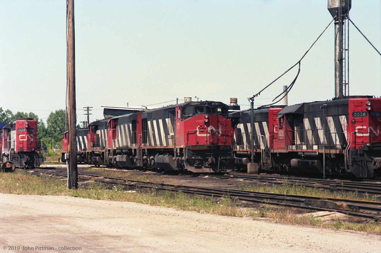 An interesting collection of CN locomotives at a terminal on 11 Aug 1991. I have mapped it as Sarnia, hope that is correct. 
From left to right are GP40 CN 9306; GP40-2W's CN 9531 and 9551; HR616's CN 2113 and 2111; a CN GP40-2W,  and SD40 CN 5036. Out of the picture to the right were GP40's CN 9304, 9302, 9305. All GMD locomotives except the Bombardier HR616's.