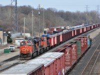 It's springtime in Southern Ontario, and thoughts turn to .... Maintenance of Way, among other things. <br>
A train of loaded Herzog side-discharge ballast cars, each with solar panels, was observed in Aldershot yard between 9AM and 3PM (when I departed), perhaps waiting for a quiet time to spread ballast.<br>
Leading the west-facing train are two ES44dc units and a Dash 9-44CW<br><br>
My source indicated that the solar panels charge batteries that power communication equipment and discharge doors. Ballast dropping with these trains is normally remotely controlled, with the important capability of stopping discharge at grade crossings and switches. <br>
Example Herzog car numbers - first hopper in red & white HZGX 10162 and a brown hopper HZGX 8427 
