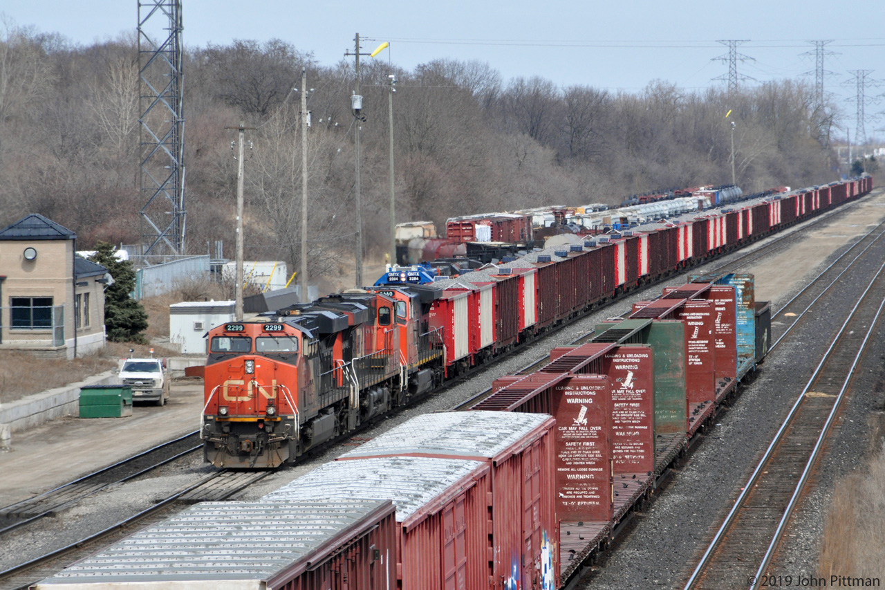 It's springtime in Southern Ontario, and thoughts turn to .... Maintenance of Way, among other things. 
A train of loaded Herzog side-discharge ballast cars, each with solar panels, was observed in Aldershot yard between 9AM and 3PM (when I departed), perhaps waiting for a quiet time to spread ballast.
Leading the west-facing train are two ES44dc units and a Dash 9-44CW
My source indicated that the solar panels charge batteries that power communication equipment and discharge doors. Ballast dropping with these trains is normally remotely controlled, with the important capability of stopping discharge at grade crossings and switches. 
Example Herzog car numbers - first hopper in red & white HZGX 10162 and a brown hopper HZGX 8427