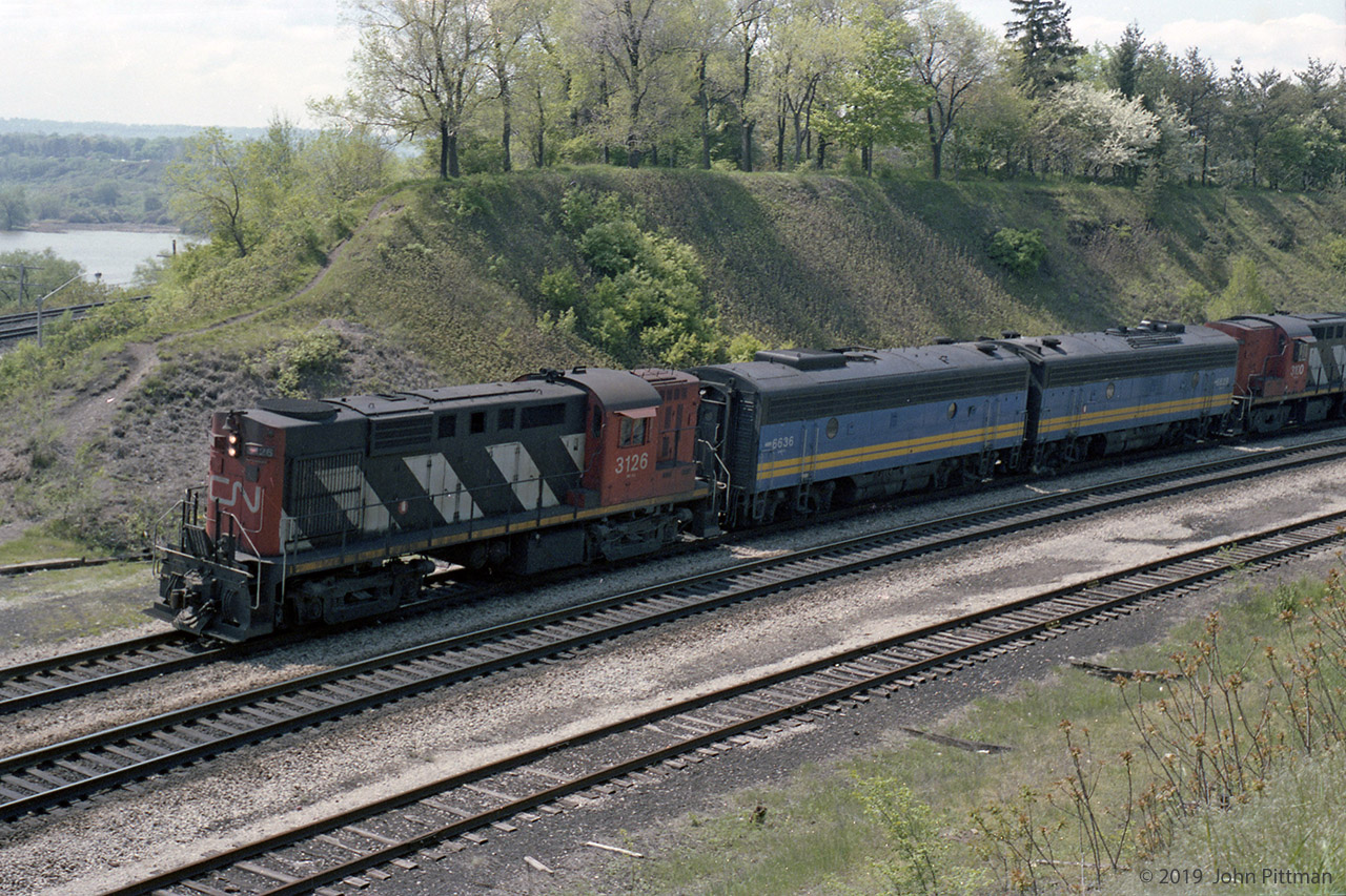 This VIA train with a mixture of CN MLW RS-18 cabs and VIA GMD F9B B-units was taken before or after a spring visit to the RBG Rock Garden. This may be the wrong side of the tracks, but the view is interesting. First coach of the train was in CN Black and Off-white, with 3-axle trucks, lots of close-together square windows, and rounded roof ends - an old fashioned look.
Unfortunately, it would be 15 years before I returned to this area and began practicing manual focus-while-zooming skills and rapid manual film advance with moving trains.