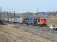 Eastbound CN train 422 originating in Port Robinson is passing through CN Snake where it crosses over to Track 1, with high-cube boxcar loads of auto parts for Ford in Oakville at the front end. <br>
Three different GE locomotives power the train - ES44ac, ET44ac, and ES44dc. <br> 
The foreman's pickup truck heading west on Track 2 surprised me, meeting 422 here.<br><br>
This viewpoint is more enjoyable while the ticks are dormant.

