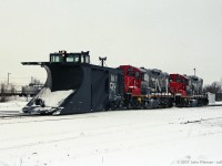 A CN plow train powered by GP9rm units CN 7034 and CN 7033 in the vicinity of CN London Yard. 
In other pictures the train was near Rectory Street grade crossing, with more snow on the plow.
Date is correct, location mapped is approximate.
