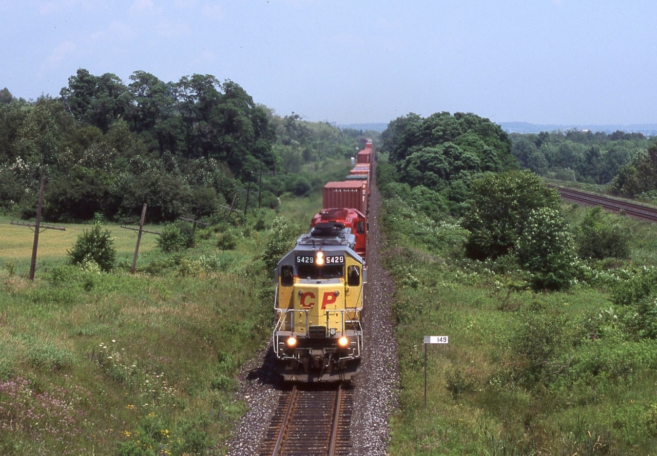 This was one of the few times I caught one of CP former UP/MP SD40’s in the lead, as CP 5429 splits the distant signals just east of Port Britain. A lot has changed here over the years. The yellow SD40’s are long gone as are the signals, which have been replaced and relocated. It’s been a few years since I’ve been out this way and it seems the old wooden farm bridges are disappearing at a fast rate as well, so not too sure if this shot is even still possible today. CN’s Kingston Subdivision can be seen off to the right here as well.