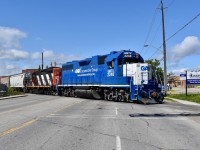 Backing down the Peel Village Industrial Lead with no more than 10 cars in tow, the power of today’s 559 is seen backing clear the busy 5 lane Clarence st crossing as they head down the spur southbound to service a few industries near Peel Village on Victoria Day Monday. Time was 10:41 and the power is GMTX 2248 and CN 4130