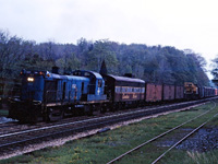 A dreary spring day in 1970 is briefly brightened by an interesting power lash-up struggling to make it up the the grade into Guelph Jct. Leased B&M RS3 1512 leads CP F7B 4441 through Campbellville...note the mixture of ice-cooled and mechanical reefers returning to U.S. roads at Windsor.