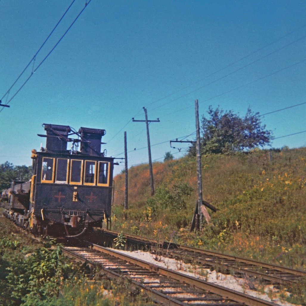 Well, a scan of an "Instamatic" print from way back when, most likely summer of 1968. A Canada Cut & Crushed Stone train along the line approaching the Brow dump facility on the escarpment overlooking Dundas. These were pretty unique trains operating on a rather obscure rail line. The railway hauled large rock from the quarry pit near Highway 5 to a primary crusher. I don't know mileage wise how track there was, perhaps 3 or 5 miles if that the electric trains operated on. Portion of the railway was double tracked and most likely spring switches at each end that enabled opposing trains to pass each other.
I googled Canada Cut and Crushed Stone and found numerous links, here is one of interest.
http://www.trainweb.org/oldtimetrains/industrial/ont/canada_crushed.htm

I was raised on the Dundas area but seldom saw this railway. "The Quarry" was a dangerous place and my parents were quite firm that I was not to go there.