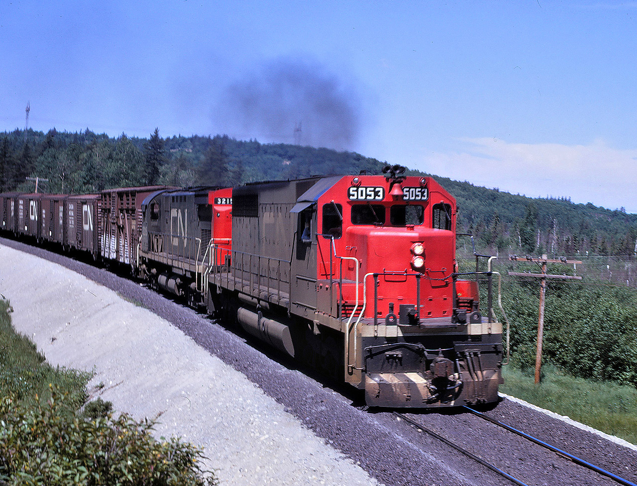 CN train 304, running as time table train 892, heads east out of Capreol on the now abandoned Alderdale Sub on July 2, 1970. The train has SD40 5053 leading C-424 3215 which was a common power arrangement at the time.  Even though heavy maintenance is evident in this picture, the line was abandoned some 20 year later.
