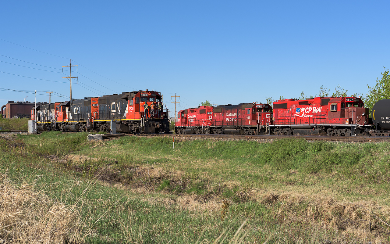 There seems to to be a very common strategy applied by the 2 major railroads with the kind of power provided for yard crews who deliver and pickup cars. For CN it is the 7530, 7520 and 7518, all former hump GP38-2's. For CP it is the 3126, 4432 and 4507. All with a different history, the 3126 is straightforward, the 4432 is a former SOO unit and the 4507 is originally a Milwaukee Road GP38-2. Although both sets of units look to be set up the same, cab end is rear on a 75hundred, thanks to Matt Watson for pointing this out. It is 8:45 and the CN midnight Scona job is only just now heading back to Clover Bar. Their night is going to get even longer as in a few minutes the way home will be blocked by derailed auto racks. At this moment in the photo, the CN units are almost over the East Edmonton diamond, while behind, CP pumps air to pull tanks out of I.O.L.