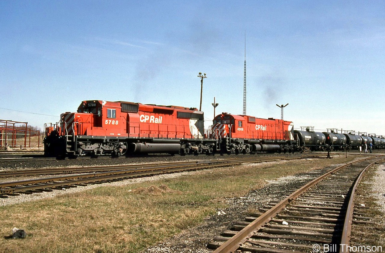 One of CP's "Acid Trains" rolls through Guelph Junction heading westbound past the station (note the station train order board signals behind the train), lead by SD40-2 5788 with white extra flags and class lights illuminated, followed by M630 4508 trailing.