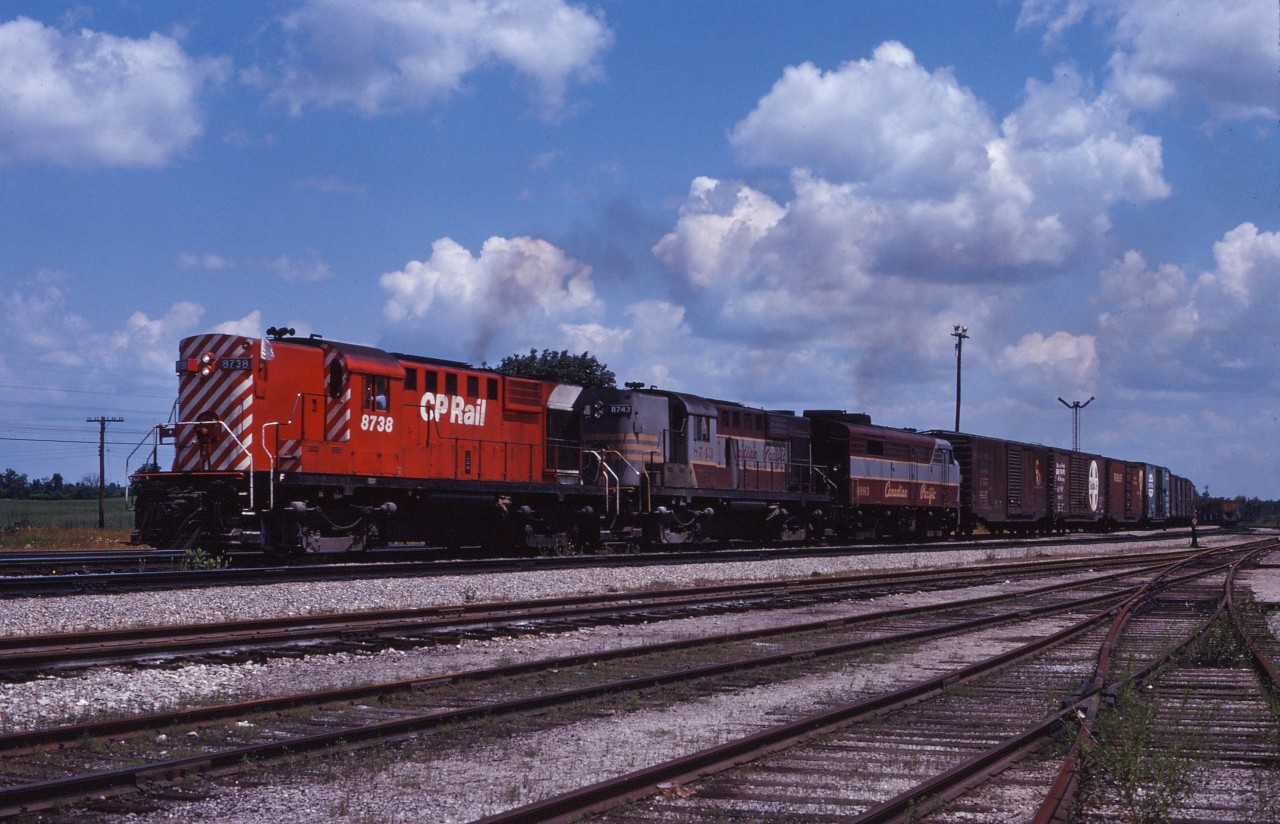 In the summer of 1970, the CP Rail image was just starting to appear on motive power and rolling stock. Here we see an RS18/RS18/FPA2 (8738, 8743, 4093)lash-up representing the "new" and the "old" paint schemes, leading a westbound extra freight through Guelph Junction on a July afternoon.