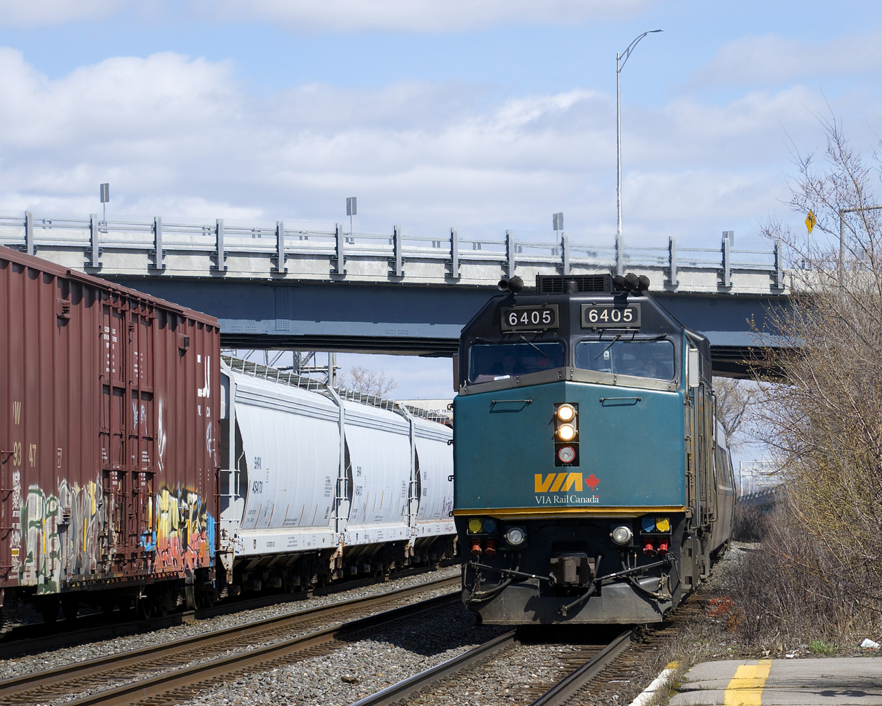 With CN 368 heading east at right, VIA 635 with VIA 6405 leading arrives at Dorval Station.