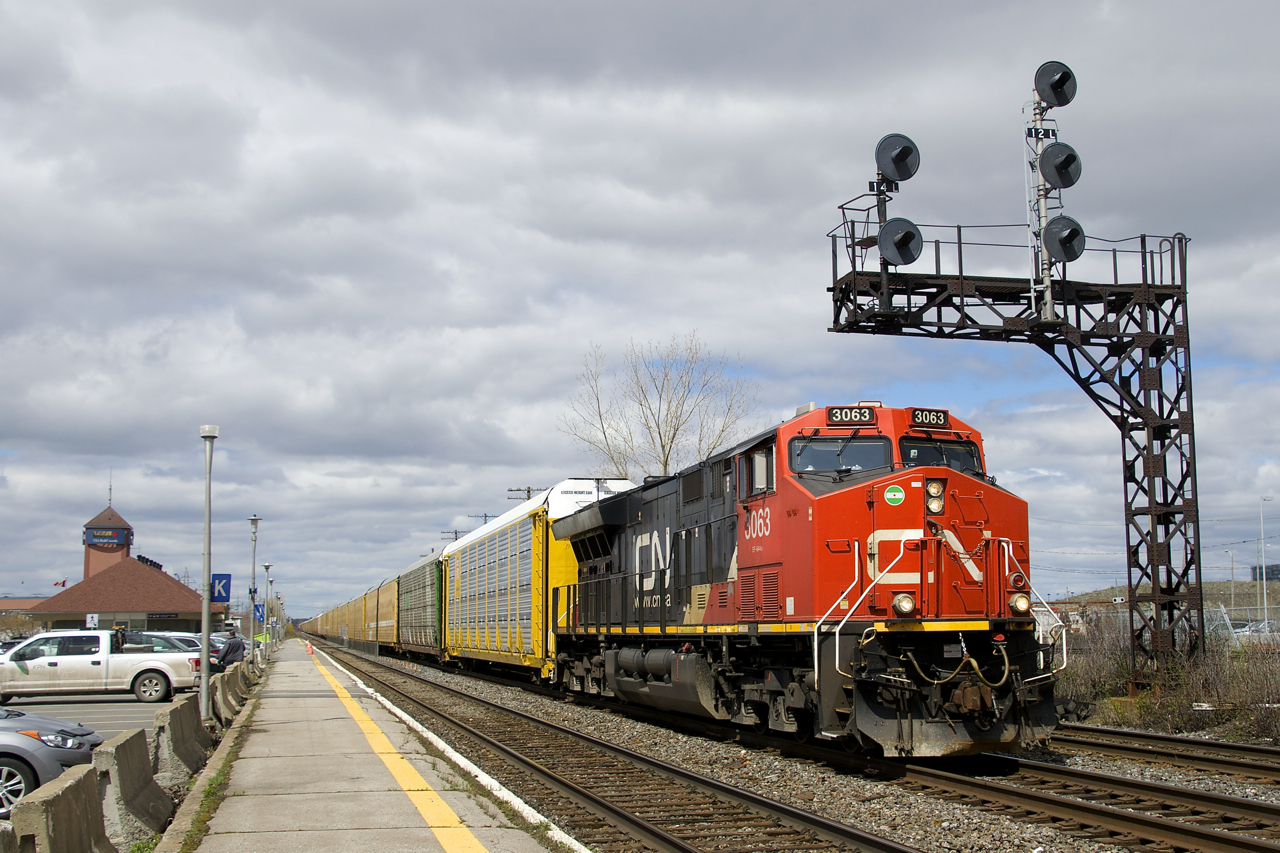 CN 368 passes underneath a classic signal gantry at Dorval just before the clouds rolled in. Power is CN 3063 up front and CN 3118 mid-train on this 137-car train.