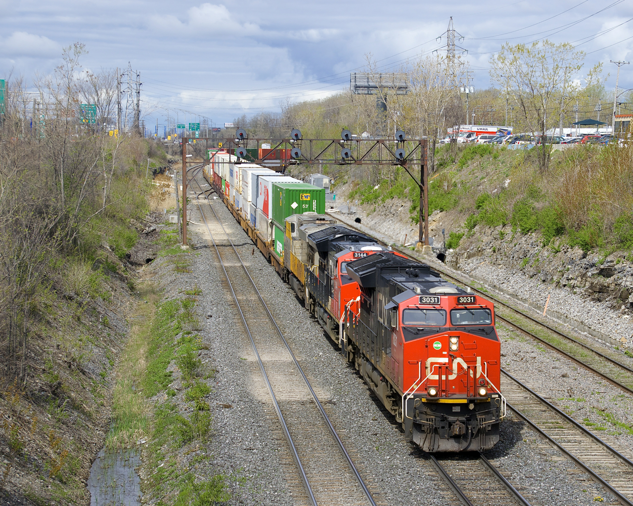 CN 3031, CN 3144 and CREX 1508 are the head-end power on CN 120 (with CN 3106 mid-train) as it exits Taschereau Yard, bound for Halifax.